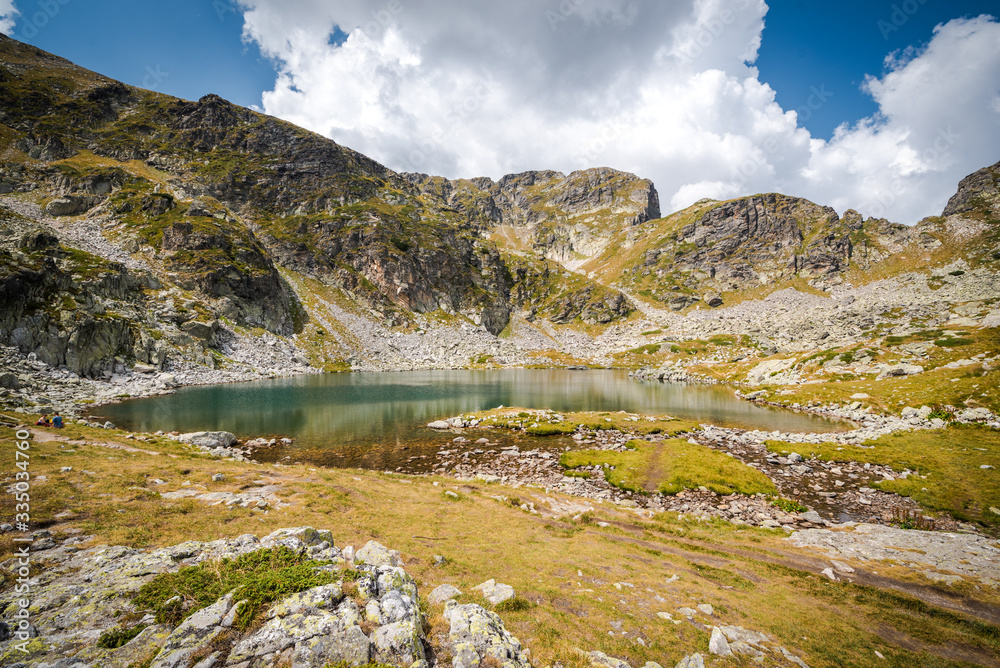 Beautiful mountain scenery - A mountain lake in a sunny day. Beauitful landscapes. Rila mountain, Bulgaria. Trekking / hiking concept. Beautiful mountain scenery - A mountain lake in a sunny day. Beauitful landscapes. Rila mountain, Bulgaria. Trekking / hiking concept.
