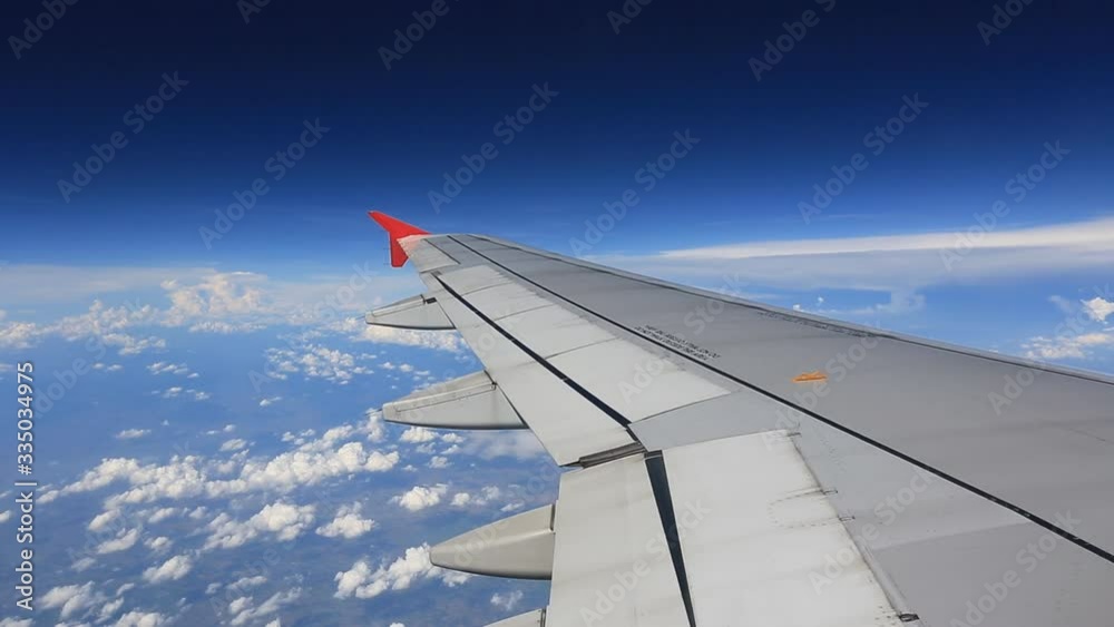 Wing of the plane on blue sky with sunlight. travel concept Wing of the plane on blue sky with sunlight. travel concept