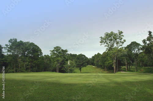 The evening golf course has sunlight shining down at golf course in Thailand