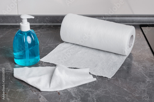 Cleaning liquid and paper towel on a kitchen table