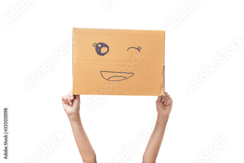 Child hand holding a cardboard box with smiley face isolated on white background. with clipping path.