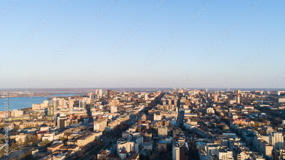 Aerial urban sunny city view from drone in spring time.Top view of Dnepr city with view of river Dnipro and different buildings blocks from the high.