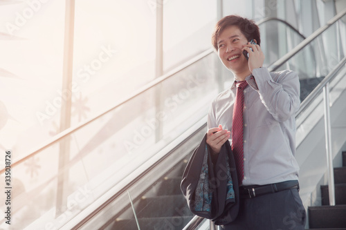 Handsome smiling confident businessman talking something on smart phone.