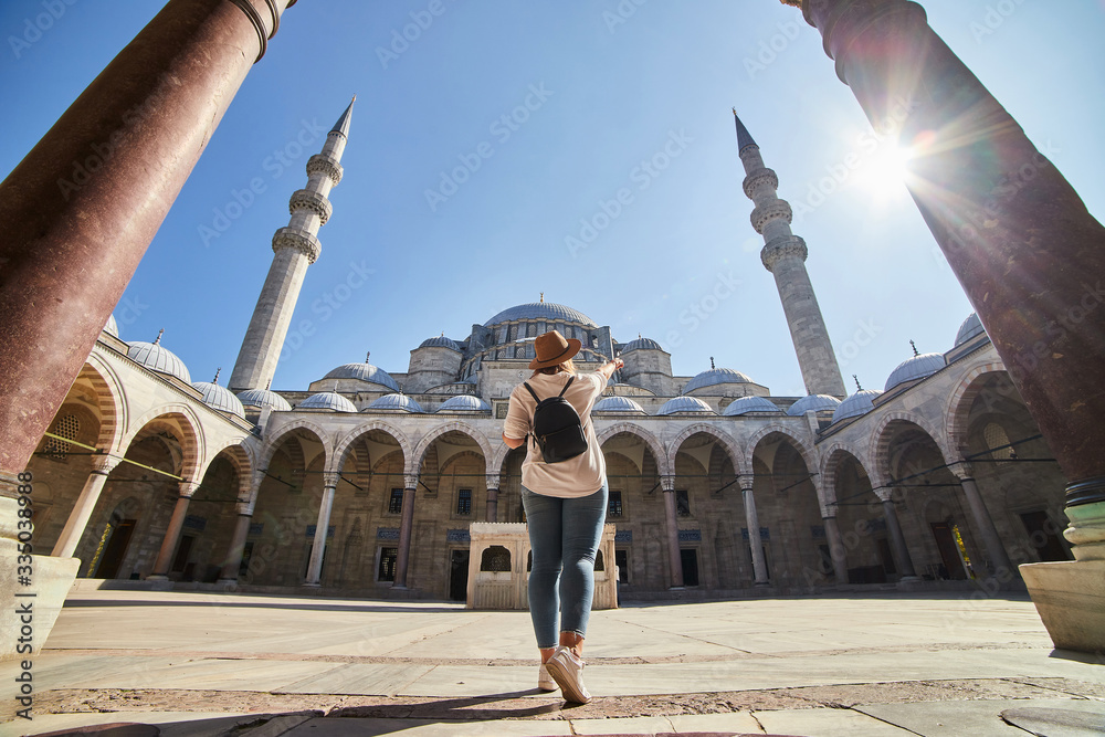 Φωτογραφία Happy attractive woman tourist in hat, posing in courtyard of Suleymaniye mosque, Istanbul, Turkey