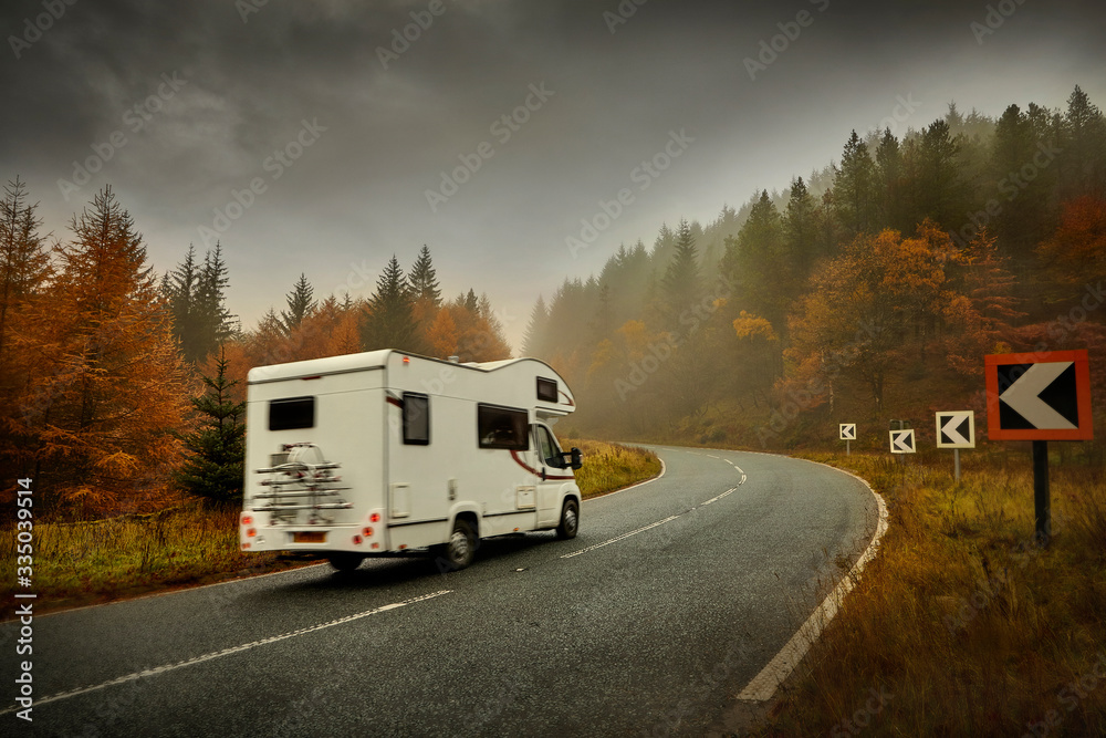 Autumn open road in forest with campervan snakepass