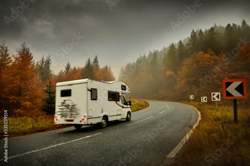 Canvas Print Autumn open road in forest with campervan snakepass
