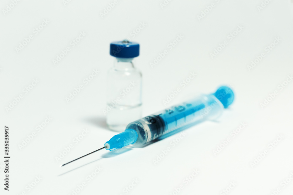 Glass medicine bottle with vaccine injection fluid with aluminium cap and syringe for vaccination, Coronavirus Covid-19 concept. Glass medicine bottle with vaccine injection fluid with aluminium cap and syringe for vaccination, Coronavirus Covid-19 concept.
