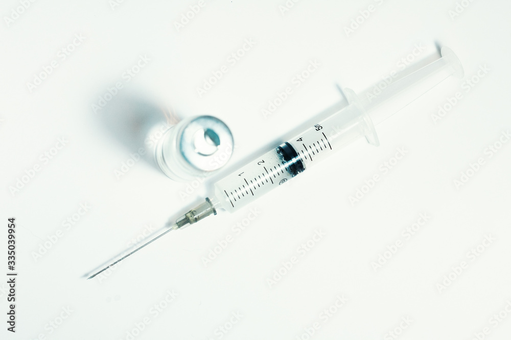 Glass medicine bottle with vaccine injection fluid with aluminium cap and syringe for vaccination, Coronavirus Covid-19 concept. Glass medicine bottle with vaccine injection fluid with aluminium cap and syringe for vaccination, Coronavirus Covid-19 concept.