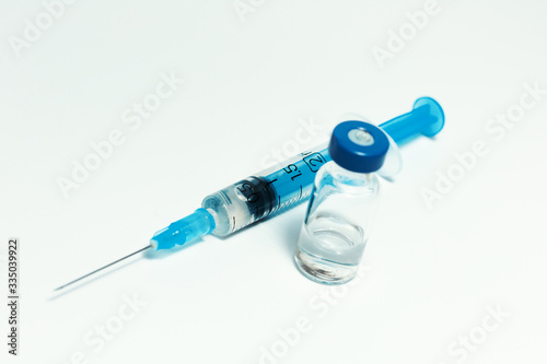 Glass medicine bottle with vaccine injection fluid with aluminium cap and syringe for vaccination, Coronavirus Covid-19 concept.