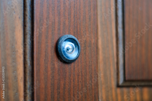 close-up of a peephole on a wooden door