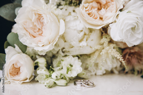 a bouquet of flowers and greenery and a wedding ring © AlexGukalovUkraine