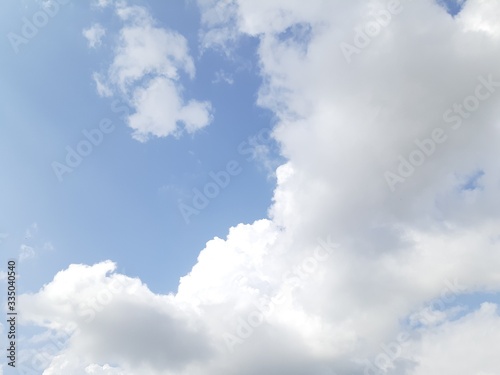 Bright blue sky with white clouds background and wallpaper cloud texture.Sun is covered with clouds.