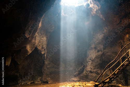 Valokuvatapetti bat cave on Lombok with beautiful sun rays coming in from the top