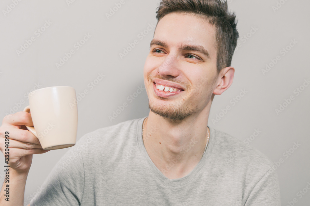 The young guy on a light background depicts different emotions The young guy on a light background depicts different emotions