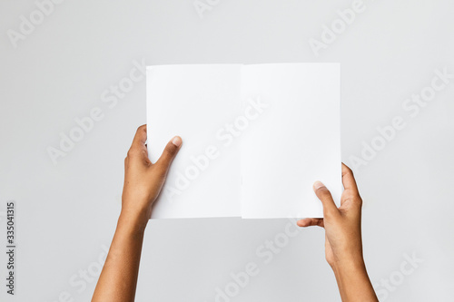 Woman of color holding and A5 or half letter size blank mockup.