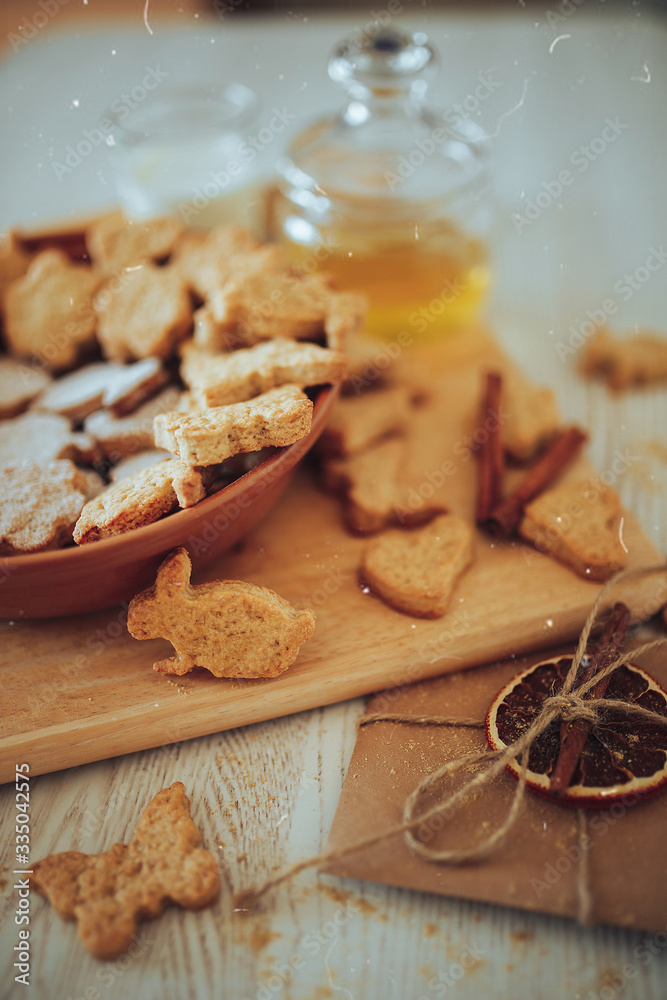 Fototapeta premium cookies lies in a plate on a wooden board, next to a jar of honey and a letter with dried orange