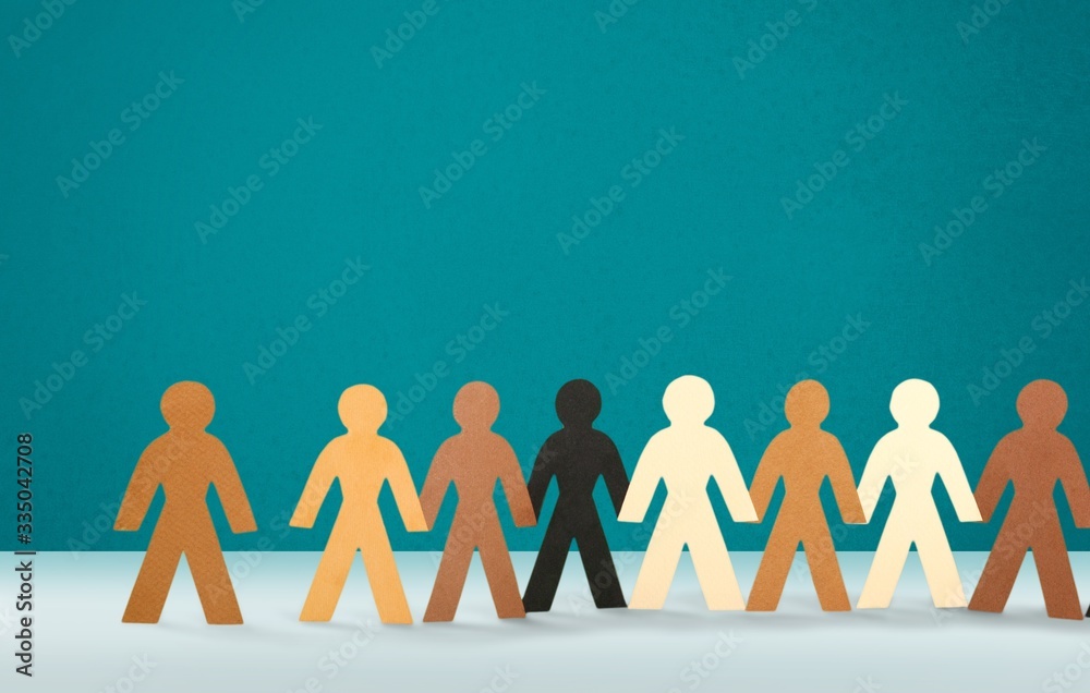 A row of paper people holding hands on the table A row of paper people holding hands on the table