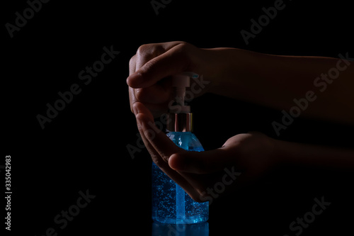 Close up. hand holding washing with alcohol 75% gel for Virus protection covid-19 or corona virus on black background.