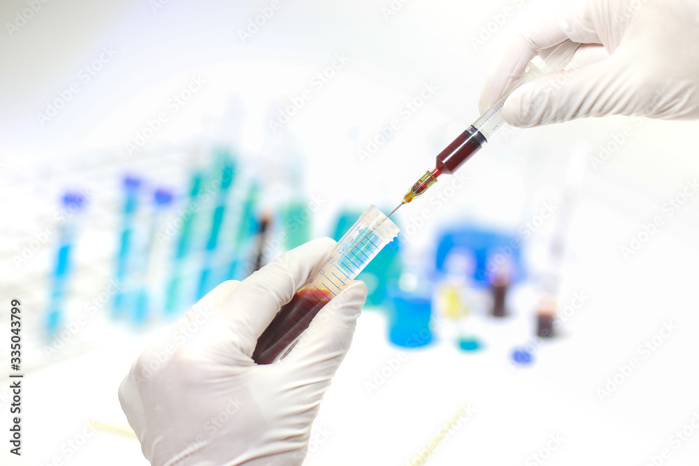 Medical or scientific researcher or man doctor looking at a test tube of clear solution in a laboratory Medical or scientific researcher or man doctor looking at a test tube of clear solution in a laboratory