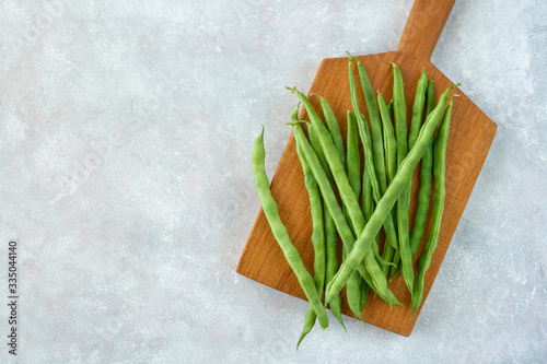 Green common bean on wooden board .Top view with copy space