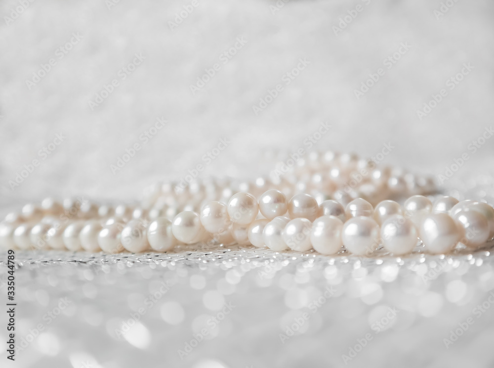Nature white string of pearls on a sparkling background in soft focus, with highlights Nature white string of pearls on a sparkling background in soft focus, with highlights