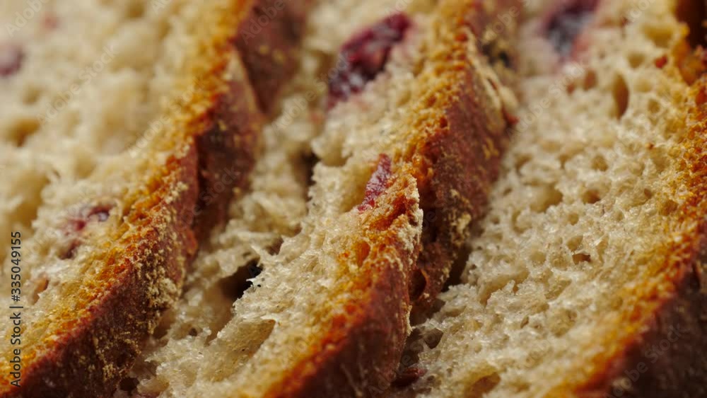 Close up of sliced rye bread with cranberry fruits, crispy crust. Fresh bread on kitchen table. Close up of sliced rye bread with cranberry fruits, crispy crust. Fresh bread on kitchen table.