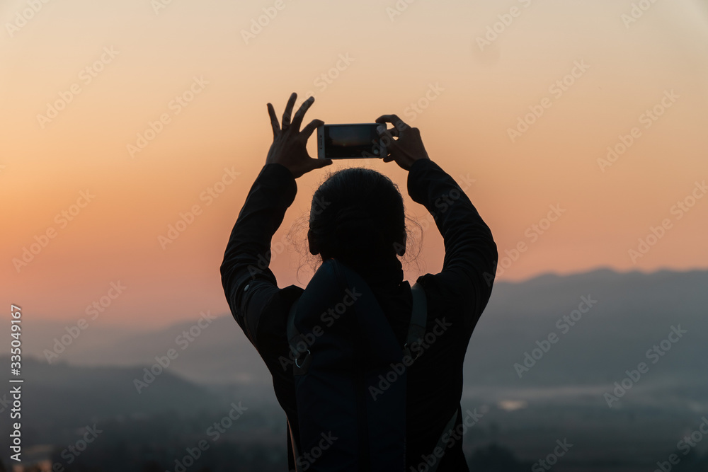 Fototapeta premium silhouette of a man making a photo at sunset