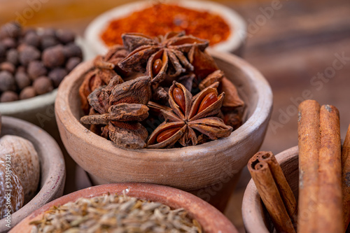 Indian spices collection, dried colorful condiment, nuts, pods and seeds and another spices in clay bowls © barmalini