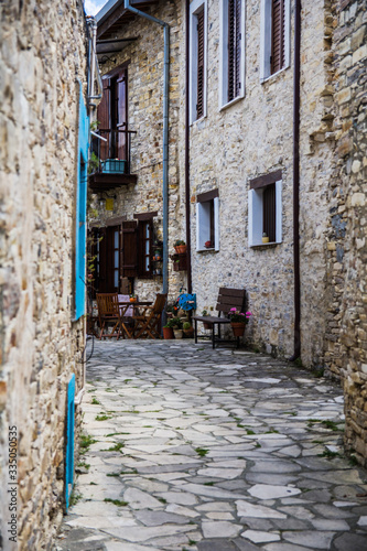 Cyprus village Lefkara. View of a village stony tiled street with lot of green and colorful walls. Selective focus