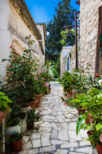 Fototapeta Naklejka Na Ścianę i Meble -  Cyprus village Lefkara. View of a village stony tiled street with lot of green and colorful walls.