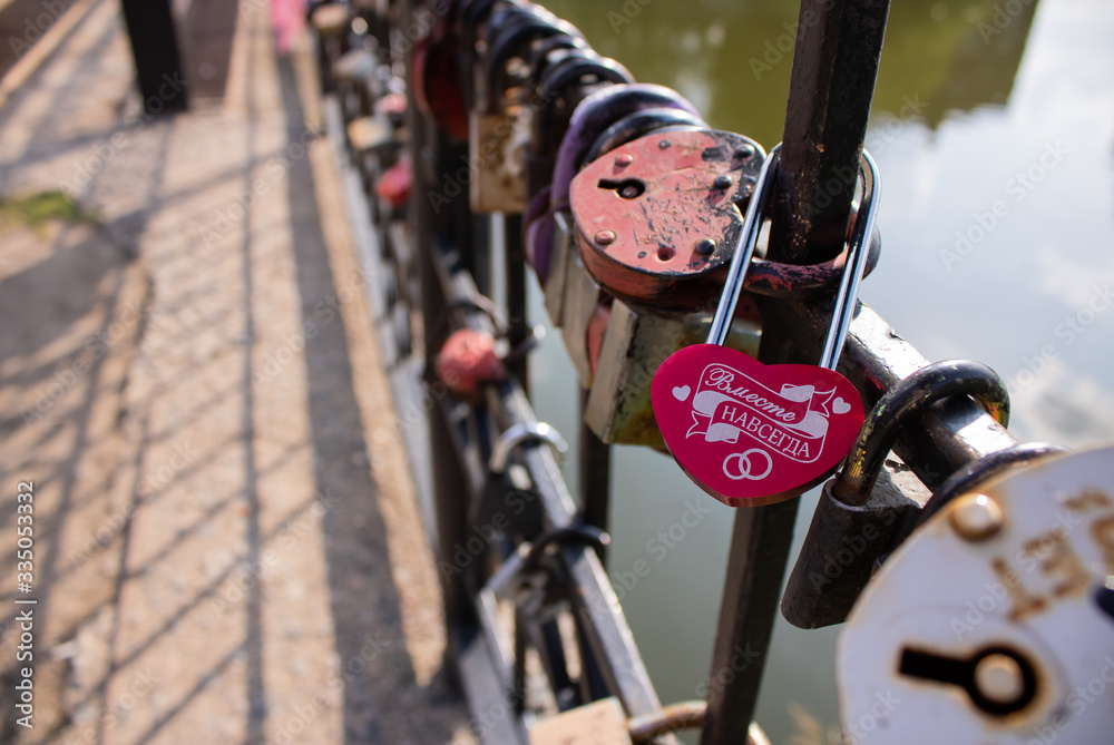 Obraz premium On the railing of the bridge hangs a bright pink padlock with the words