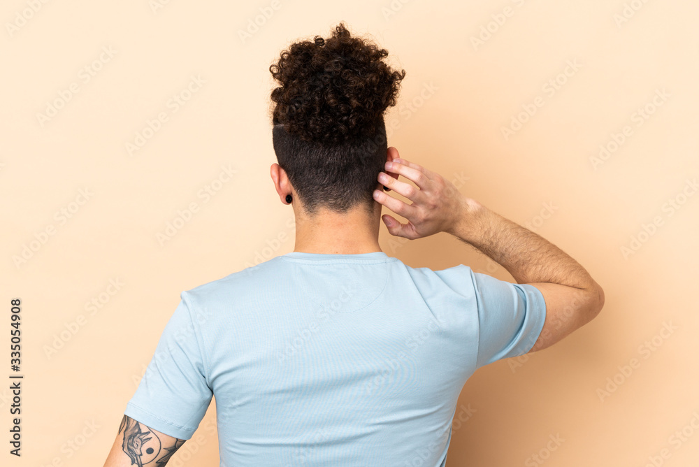 Caucasian man over isolated background in back position and thinking Caucasian man over isolated background in back position and thinking