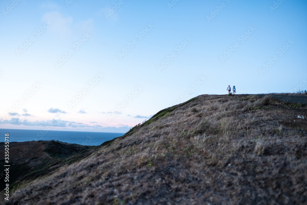 Fototapeta premium 2 Women Hiking On a Hilltop - social distancing - Hanama bay, Oahu, HI - September 11, 2018