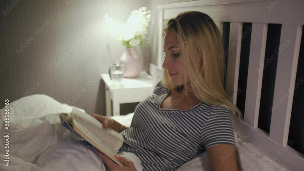 Woman in night underwear reading book before sleeping Woman in night underwear reading book before sleeping