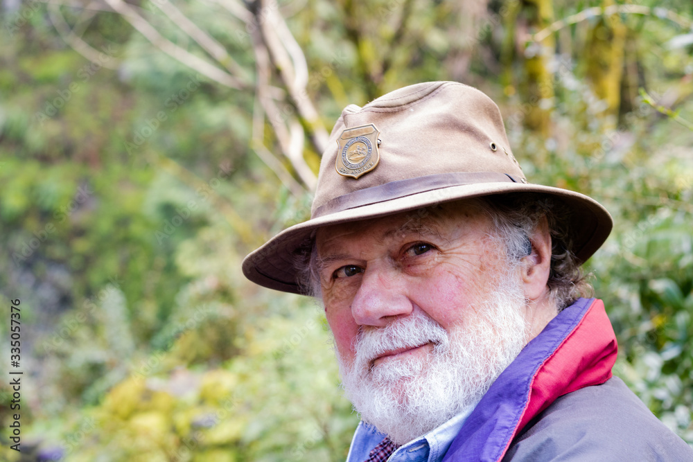 Serious wise thoughtful kind bearded senior male, outside in forest background