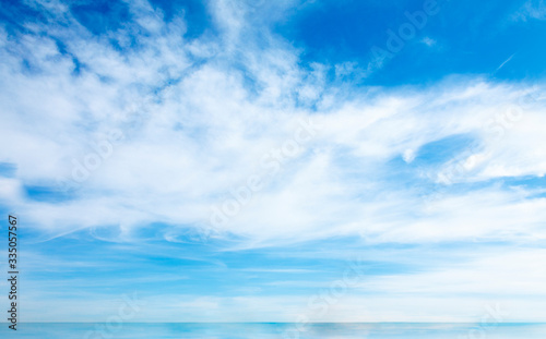 Full frame of blue sky with clouds and skyline above the water