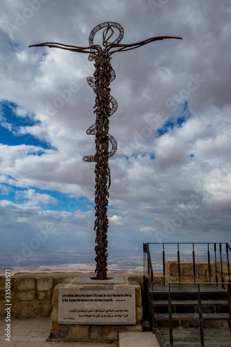 The Brazen Serpent on Mount Nebo, next to Moses Memorial Basilica, Kingdom of Jordan, scenery view with the Promised Lands, Israel. Cloudy winter afternoon sky.