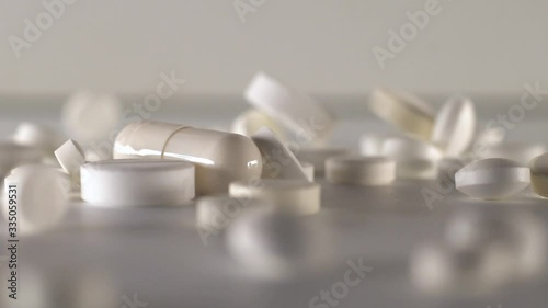 Many white pills falling white background.Macro