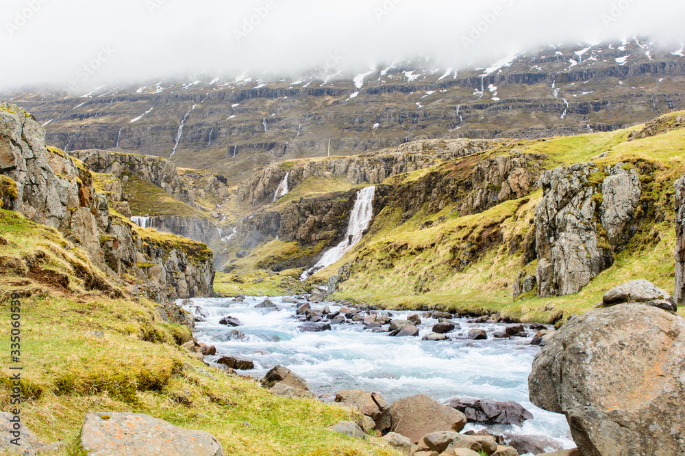 Waterfall in winter, Reyoarfjorour fjord, Iceland.