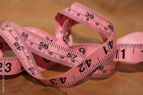 Measuring tape on brown background