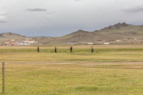 Altai, Mongolia - June 14, 2017: Mongolian men working in the field, mowing the grass