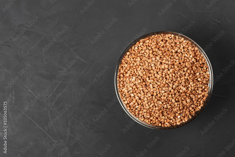 Glass container with buckwheat on a black background with copy space. Glass container with buckwheat on a black background with copy space.