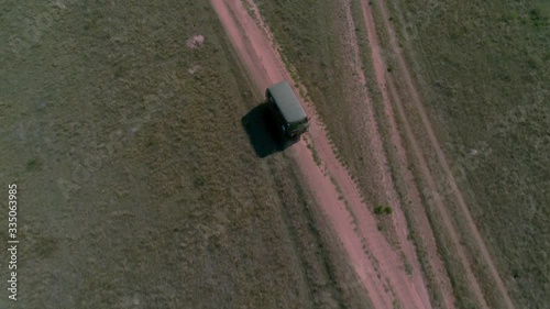 Aerial footage filmed with drone of pickup car riding in steppe. the car travels along the steppe to Siberia, roads laid along the Baikal island through the grassy hills. Russian car buhanka photo