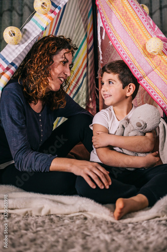 Mother and son having fun on a tent at home