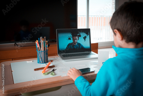 Kid studying homework math during his online lesson at home, social distance during quarantine. Self-isolation and online education concept caused by coronavirus pandemia photo