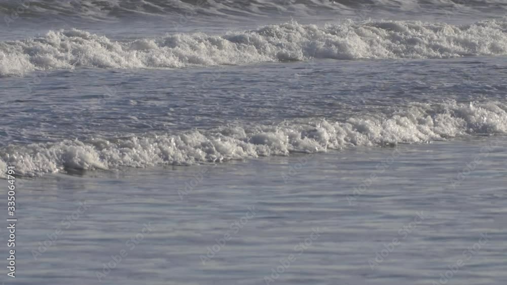 Foamy waves crashing on the shore in slow motion Foamy waves crashing on the shore in slow motion