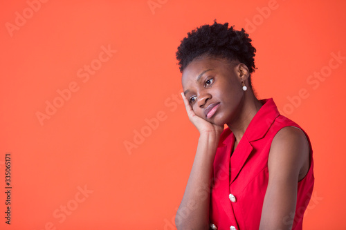 portrait of a beautiful young african woman on red background © Alexandr