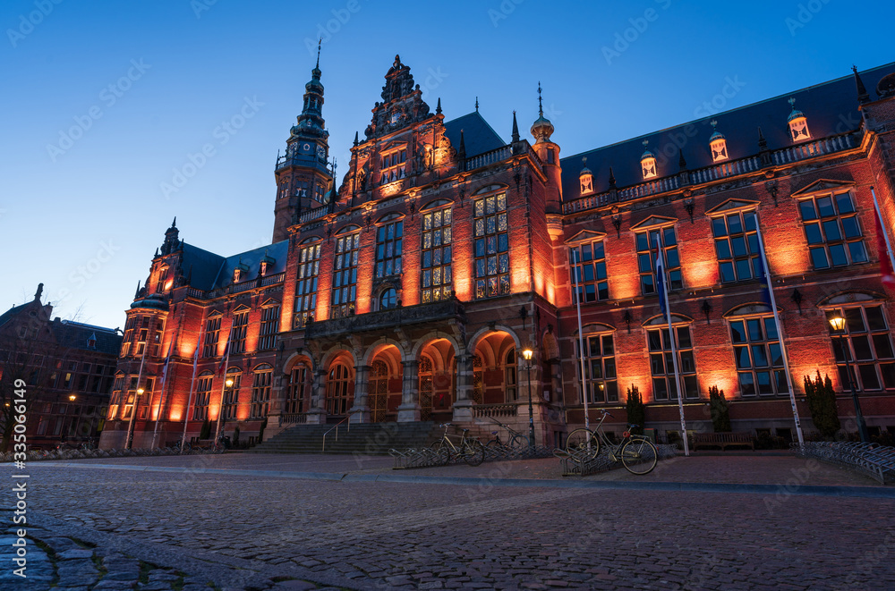 University and empty square in the old town of Groningen illuminated at twilight.