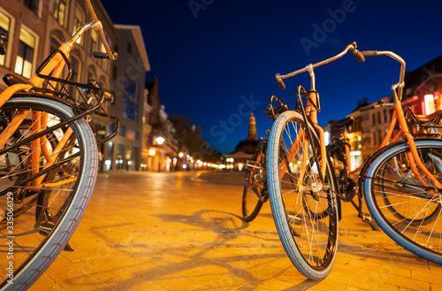 Rental student bicycles on the Vismarkt during twilight in the city of Groningen, the Netherlands.