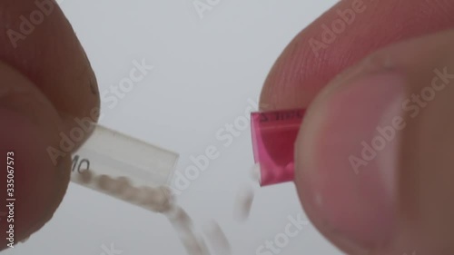 Fingers open the medicine capsule, granules are poured,macro